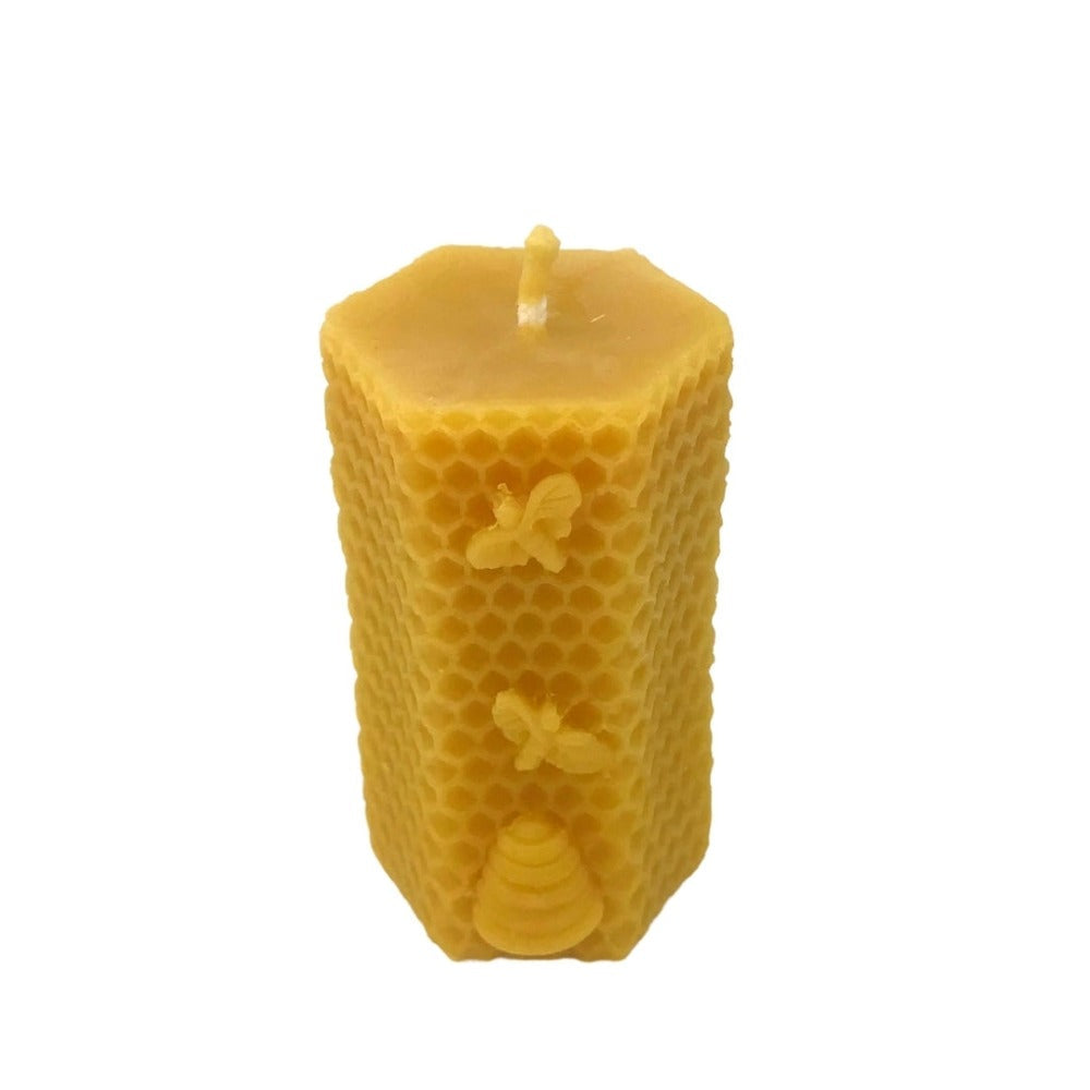 Beeswax candle moulded with bees on a honeycomb pattern
